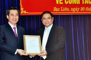 Đồng chí Phạm Minh Chính (phải) trao quyết định của Bộ Chính trị cho đồng chí Nguyễn Quang Dương 