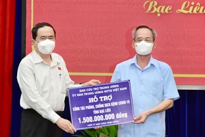 Đồng chí Trần Thanh Mẫn (bìa trái) trao bảng tượng trưng hỗ trợ kinh phí 1,5 tỷ đồng cho công tác phòng, chống dịch Covid-19 tỉnh Bạc Liêu
