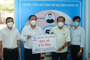 Giám đốc Công ty Điện lực Cà Mau Huỳnh Hữu Quang (thứ 2 từ trái sang), đại diện Tổng Công ty Điện lực miền Nam trao bảng tượng trưng số tiền hỗ trợ cho Ủy ban MTTQ Việt Nam tỉnh Cà Mau. Ảnh: NGỌC HÂN