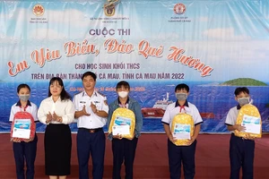 Thượng tá Dương Xuân Dũng, Chính ủy Hải đoàn 42 trao quà cho các em học sinh có hoàn cảnh khó khăn tại TP Cà Mau