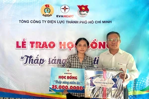 Phó Tổng Giám đốc EVNHCMC Bùi Trung Kiên trao quà và học bổng cho em Lê Ngọc Như Ý (xã Thái Mỹ, huyện Củ Chi, TPHCM)