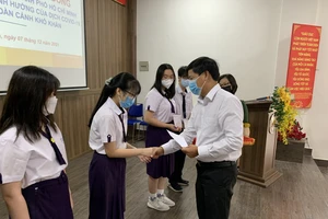 Ông Lê Văn Minh, Chủ tịch Công đoàn EVNHCMC trao học bổng cho 6 em học sinh trường THPT Nguyễn Thị Minh Khai có hoàn cảnh đặc biệt vì dịch Covid-19