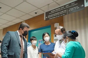 Ông Lennor Carrillo (trái), Tổng giám đốc Roche Pharma Việt Nam, trao đổi với bác sĩ Bệnh viện Đại học Y Dược TPHCM