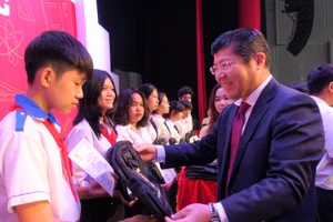 Ông Tsutomu Nara – Tổng giám đốc công ty Ajinomoto Việt Nam trao học bổng và cặp sách cho học sinh