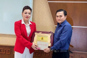 Bà Huỳnh Lan Phương nhận kỷ niệm chương và thiệp chúc tết từ ông Cao Thanh Bình, Trưởng Ban Văn hóa Xã hội HĐND TPHCM