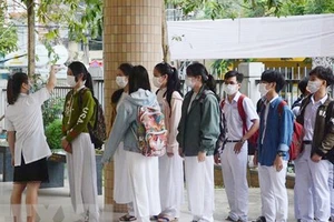 Các học sinh Trường THPT Phan Châu Trinh (thành phố Đà Nẵng) xếp hàng đo thân nhiệt trước khi vào lớp. Ảnh: TTXVN