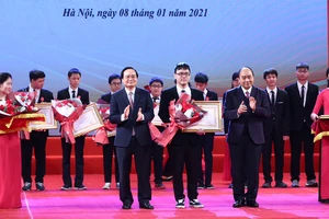 Thủ tướng Nguyễn Xuân Phúc và Bộ trưởng Bộ GD-ĐT Phùng Xuân Nhạ trao thưởng cho các em học sinh. Ảnh: VIẾT CHUNG