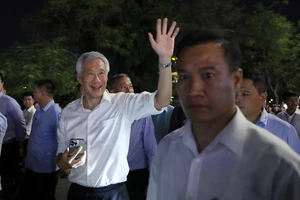 Thủ tướng Singapore Lý Hiển Long chào người dân khi dạo phố đi bộ bên hồ Hoàn Kiếm và thăm đền Ngọc Sơn, tối 27-8. Ảnh: QUANG PHÚC