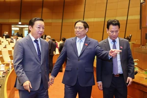 Thủ tướng Phạm Minh Chính trao đổi với Phó Thủ tướng Trần Hồng Hà và Bộ trưởng Bộ TN-MT tại phiên họp Quốc hội thảo luận về dự thảo Luật Đất đai (sửa đổi) sáng 15-1. Ảnh: QUANG PHÚC