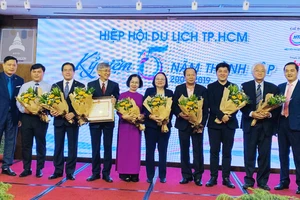 Các lãnh đạo, thành viên Hiệp hội Du lịch TPHCM nhận hoa chúc mừng ngày 11-1. Ảnh: THI HỒNG