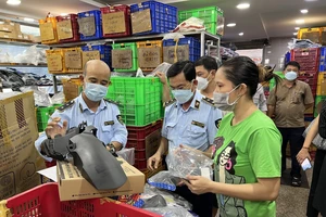 Quản lý thị trường kiểm tra hàng hóa và làm việc với đại diện một cửa hàng tại chợ Tân Thành 