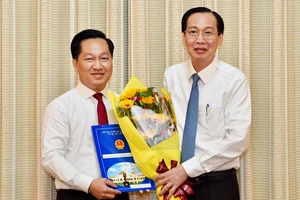 Đồng chí Lê Thanh Liêm, Phó Chủ tịch Thường trực UBND TPHCM trao quyết định cho đồng chí Hoàng Tùng. Ảnh: VIỆT DŨNG