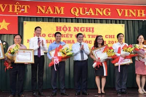 Chủ tịch UBND TPHCM Nguyễn Thành Phong và Phó Chủ tịch UBND Trần Vĩnh Tuyến tặng bằng khen cho các doanh nghiệp. Ảnh: VIỆT DŨNG