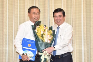 Chủ tịch UBND TPHCM Nguyễn Thành Phong trao quyết định điều động và bổ nhiệm cho ông Huỳnh Thanh Nhân. Ảnh: VIỆT DŨNG