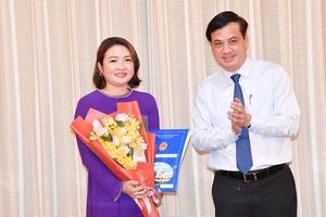 Phó Chủ tịch UBND TPHCM Lê Hòa Bình trao quyết định cho bà Bùi Thị Ngọc Hiếu. Ảnh: VIỆT DŨNG