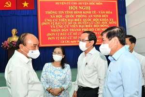 Chủ tịch nước Nguyễn Xuân Phúc trao đổi cùng các đồng chí lãnh đạo TPHCM tại hội nghị. Ảnh: VIỆT DŨNG