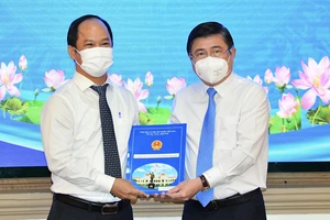 Chủ tịch UBND TPHCM Nguyễn Thành Phong trao quyết định cho Đồng chí Lê Đức Thanh. Ảnh: VIỆT DŨNG 