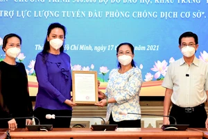 Chủ tịch HĐND TPHCM Nguyễn Thị Lệ tiếp nhận và trao thư cám ơn Công ty Bảo trợ Tập đoàn Vạn Thịnh Phát. Ảnh: VIỆT DŨNG 
