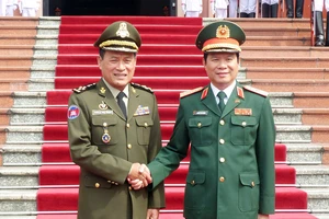Thượng tướng Nguyễn Tân Cương tặng hoa Đại tướng Vong Pisen tại lễ đón chính thức. Ảnh T.B 