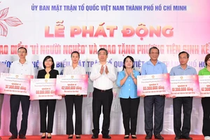 Phó Bí thư Thành ủy TPHCM Nguyễn Phước Lộc và Chủ tịch Ủy ban MTTQ Việt Nam TPHCM Trần Kim Yến trao bảng tượng trưng hỗ trợ phương tiện sinh kế cho hộ nghèo trong năm 2023 đến các quận, huyện và TP Thủ Đức. Ảnh: VIỆT DŨNG