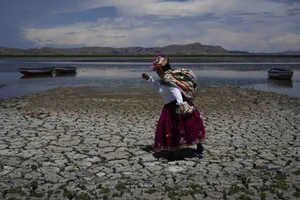 Một người dân Peru di chuyển qua lòng sông khô cạn vì hạn hán. Ảnh: REUTERS