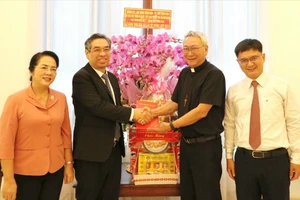Đồng chí Nguyễn Phước Lộc chúc mừng Giám mục Nguyễn Hồng Sơn. Ảnh: NGÔ BÌNH