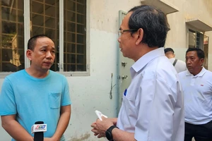 Bí thư Thành ủy TPHCM Nguyễn Văn Nên thăm, động viên gia đình có nhà bị cháy. Ảnh: THU HOÀI 