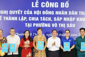 Phó Chủ tịch HĐND TPHCM Phạm Thành Kiên cùng Bí thư Quận ủy quận 3 Nguyễn Thanh Xuân trao quyết định và tặng hoa chúc mừng đại diện các khu phố mới