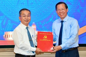 Chủ tịch UBND TPHCM trao quyết định đến đồng chí Võ Ngọc Quốc Thuận. Ảnh: VIỆT DŨNG