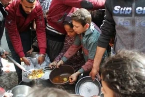 Người dân Palestine tại Dải Gaza xếp hàng chờ phát đồ ăn. Ảnh: REUTERS