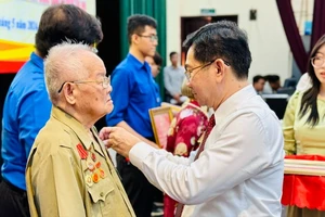Chủ nhiệm Ủy ban Kiểm tra Thành ủy TPHCM Dương Ngọc Hải trao Huy hiệu Đảng cho đảng viên cao tuổi Đảng ở quận Tân Phú. Ảnh: CHÍ THẠCH