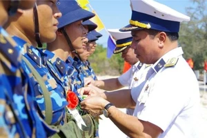 Đại tá Nguyễn Văn Bách, Tư lệnh Vùng 4 quân chủng Hải quân biểu dương kết quả bắn trên bia của chiến sĩ mới. Ảnh: TTXVN
