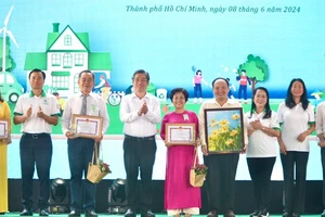 Đồng chí Nguyễn Phước Lộc, Phó Bí thư Thành ủy TPHCM trao tặng bằng khen cho các tổ chức, cá nhân đã có nhiều thành tích đóng góp trong công tác bảo vệ môi trường. Ảnh: HOÀNG HÙNG