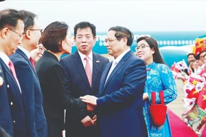 Quan chức Hàn Quốc đón Thủ tướng Phạm Minh Chính và phu nhân tại sân bay quân sự Seongnam, tỉnh Gyeonggi. Ảnh: TTXVN
