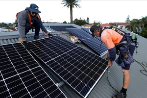 Lắp đặt các tấm pin năng lượng Mặt trời trên mái một ngôi nhà ở TP Sydney, Australia. Ảnh: BLOOMBERG