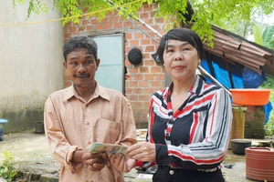 Lãnh đạo Hội Chữ thập đỏ xã Ân Đức đại diện trao số tiền bạn đọc Báo SGGP giúp gia đình ông Nguyễn Văn Khỏi