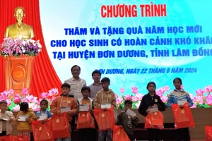 Phó Bí thư Thường trực Đảng ủy Khối Doanh nghiệp TPHCM Đỗ Văn Tuấn và đại diện Huyện ủy Đơn Dương trao quà các em học sinh