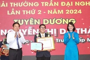 Phó Chủ tịch UBND TPHCM Trần Thị Diệu Thúy trao giải thưởng cho nhà giáo Nguyễn Quang Nguyên, Trường Cao đẳng Kinh tế TPHCM. Ảnh: QUANG HUY