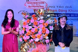Phó Giám đốc NVH Thanh Niên - MC, ca sĩ Quỳnh Hoa tặng hoa chúc mừng NS Phạm Đăng Khương trong buổi ra mắt tập sách nhạc và sách ảnh. Ảnh: THÚY BÌNH