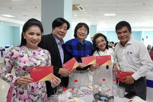 Ông Cao Anh Minh, Tổng Giám đốc Đài Truyền hình TPHCM lì xì và chúc xuân các nghệ sĩ tham gia buổi họp mặt văn nghệ sĩ đầu năm mới 2024. Ảnh: THÚY BÌNH