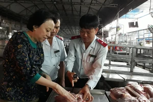 Lực lượng chức năng đang tiến hành kiểm tra thực phẩm tại chợ đầu mối Hóc Môn