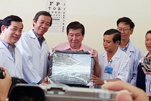Bác sĩ Nguyễn Văn Vĩnh Châu, Giám đốc Bệnh viện Bệnh Nhiệt đới tặng bệnh nhân H. bức hình lưu niệm