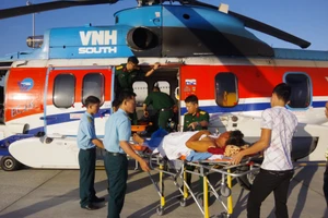 Các chiến sĩ, bác sĩ vận chuyển bệnh nhân từ trực thăng về bệnh viện Ảnh: TRẦN CHÍNH