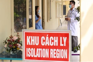 Bác sĩ Lê Quang Nhựt hỏi thăm sức khỏe người cách ly tại Khu cách ly quận 3. Ảnh: HOÀNG HÙNG