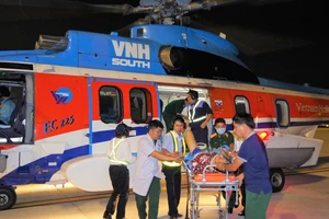 Lực lượng nhân viên y tế và nhân viên sân bay vận chuyển bệnh nhân từ trực thăng về bệnh viện