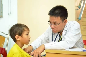 PGS-TS-BS Lê Minh Khôi đang thăm khám cho bệnh nhi