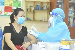 Nhân viên y tế tiêm vaccine cho người dân tại Trường Tiểu học Bình Hưng, huyện Bình Chánh. Ảnh: CAO THĂNG