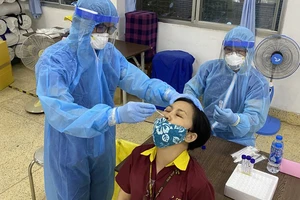 Nhân viên y tế lấy mẫu xét nghiệm cho người lao động Khu chế xuất Tân Thuận