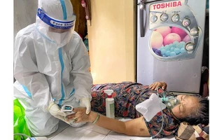 Nhân viên y tế phường Nguyễn Cư Trinh (quận 1) đến tận nhà cấp cứu bệnh nhân khó thở. Ảnh: HOÀNG HÙNG
