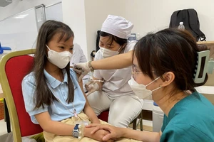 Nhân viên y tế tiêm vaccine cho trẻ em